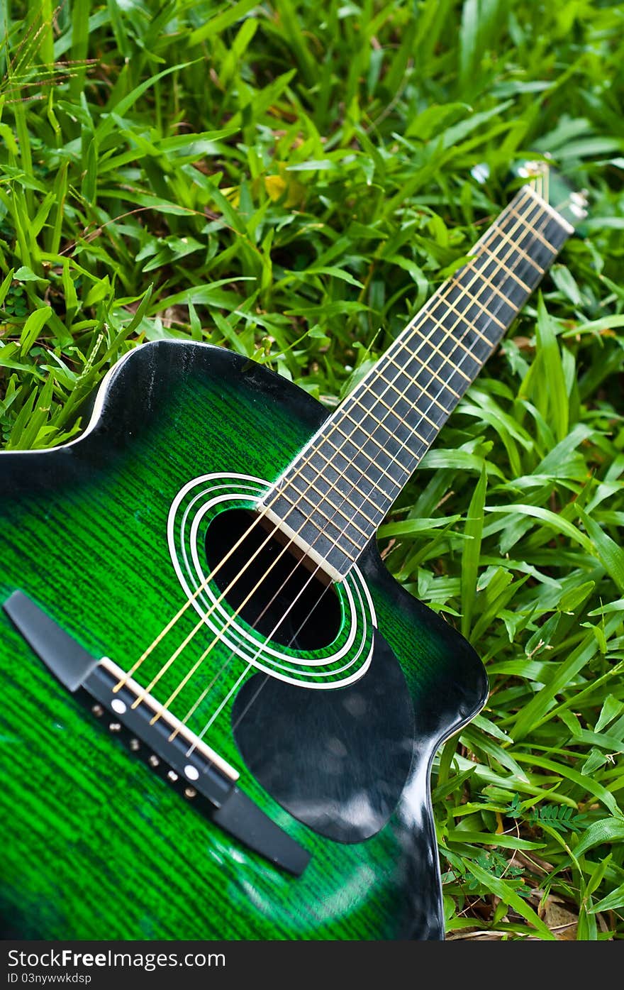 Acoustic guitar with green grass background