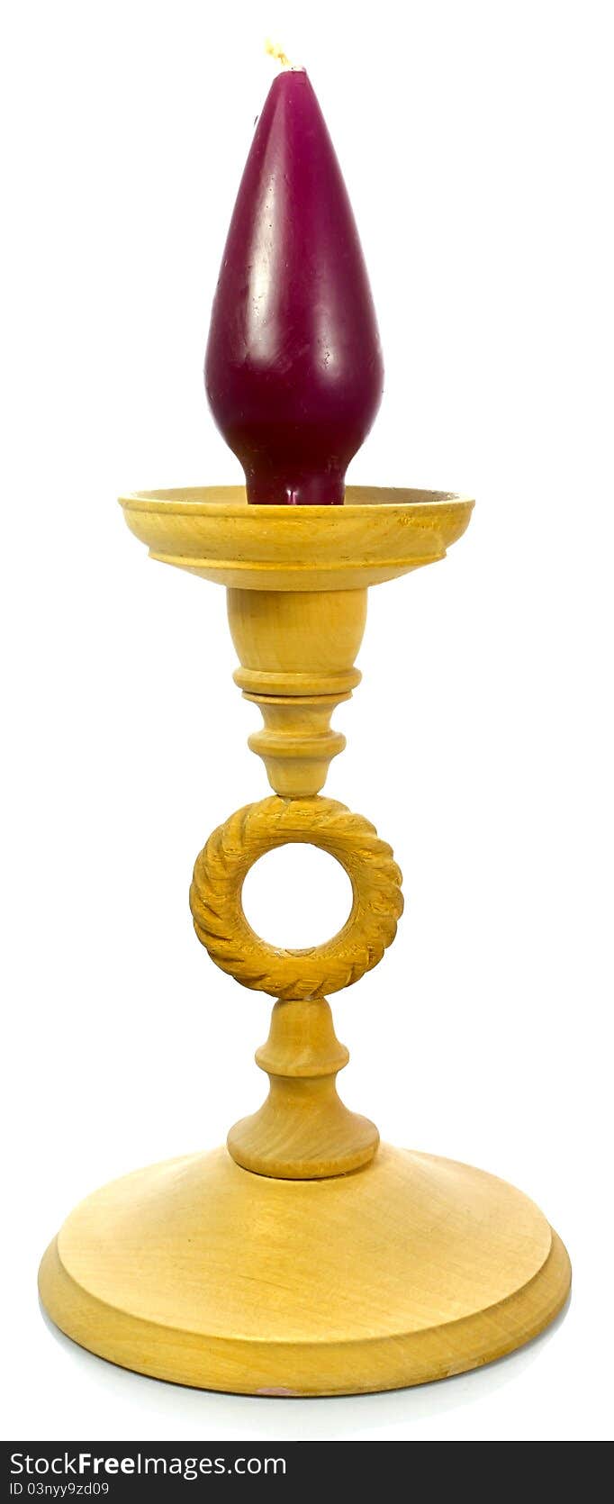 Wooden candlestick with a purple candle on top.