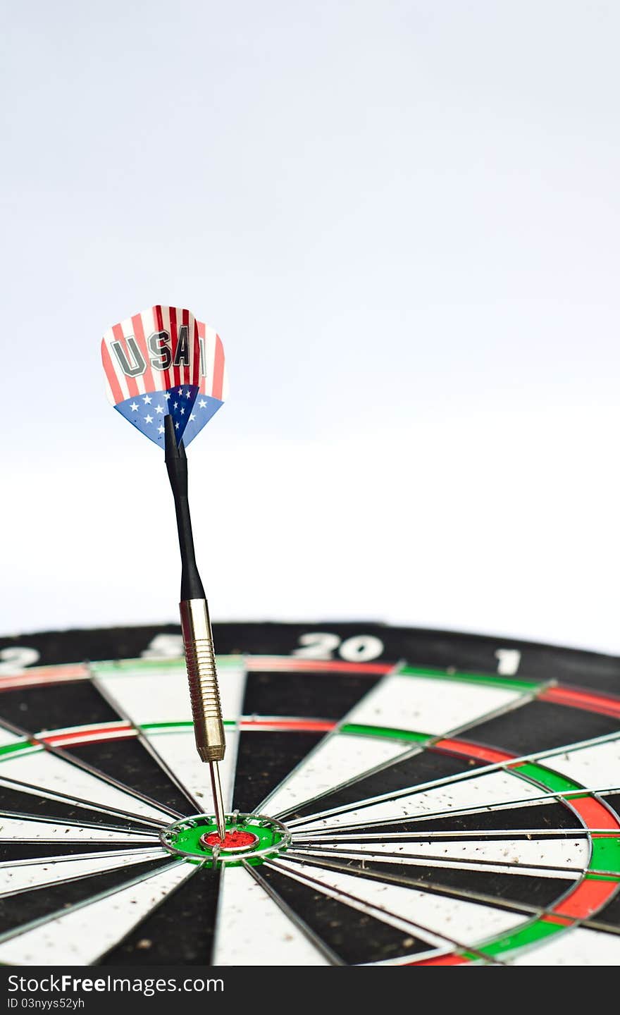 Dart in center of dartboard with white background. Dart in center of dartboard with white background