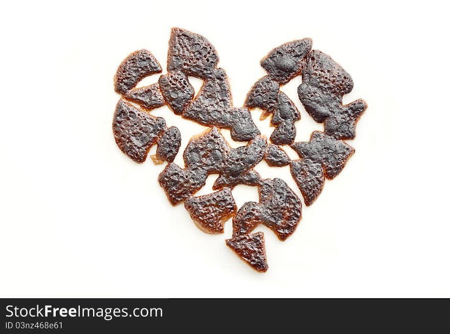 Broken heart isolated on a white background made of burnt chocolate. Broken heart isolated on a white background made of burnt chocolate.