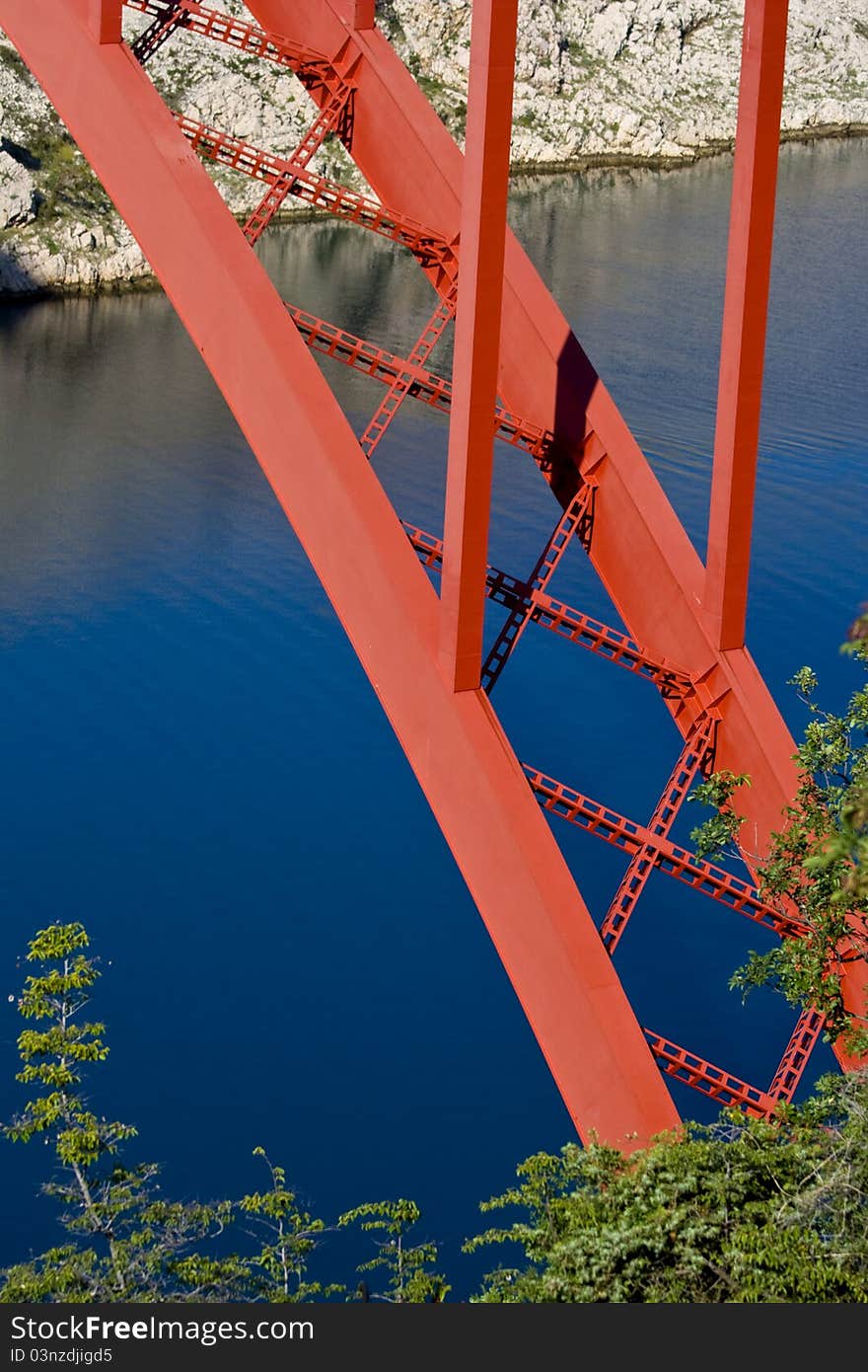 Red Maslenica bridge, blue water, white rocks and the green tree. Red Maslenica bridge, blue water, white rocks and the green tree