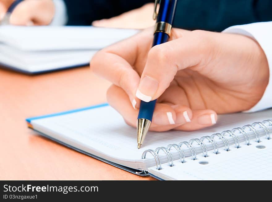 Hand of young woman taking notes