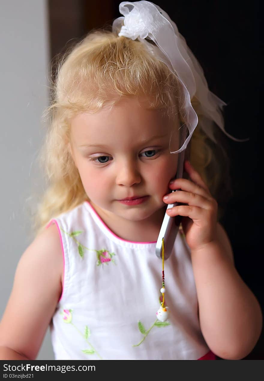 Little beautiful caucasian girl listening to mobile phone. Little beautiful caucasian girl listening to mobile phone