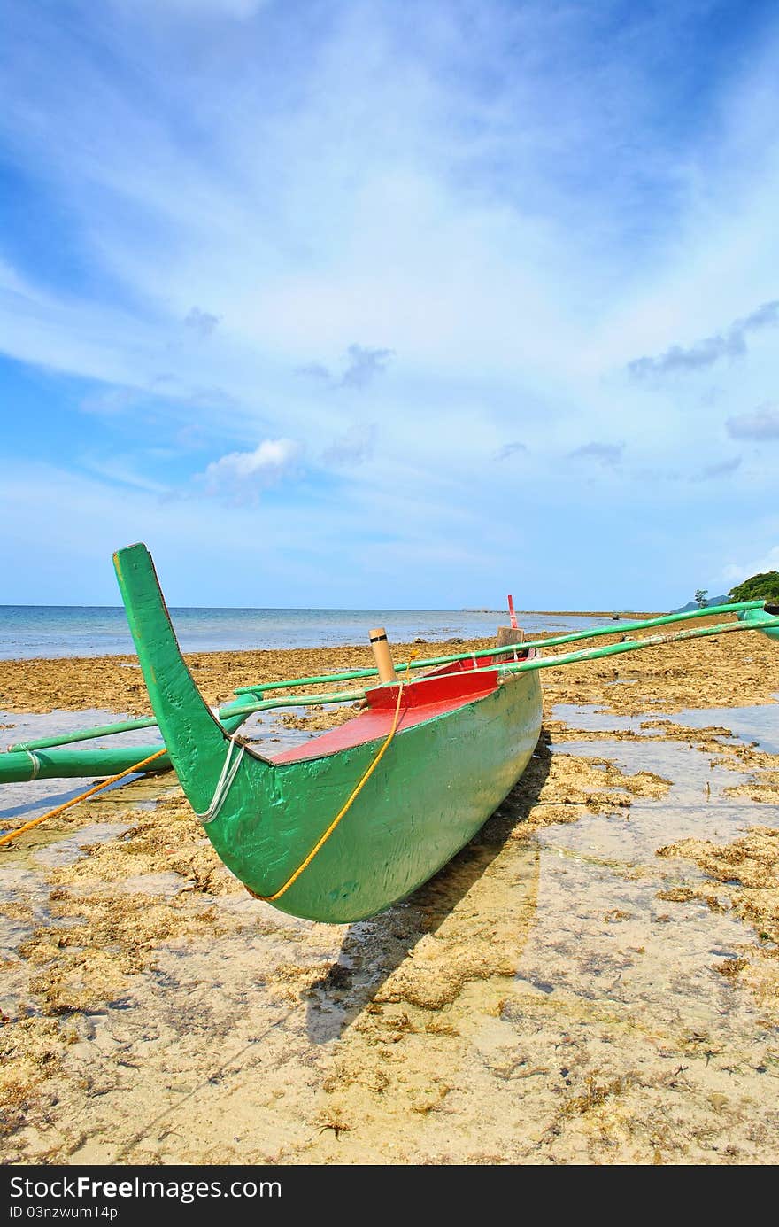 A traditional fishing boat docked during low tide. (Philippines)