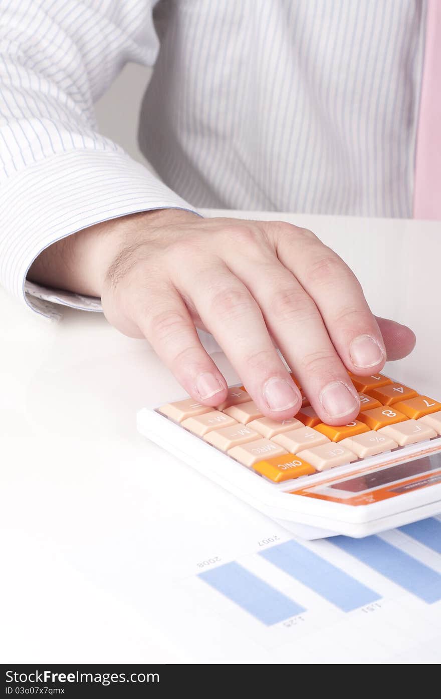 A businessman at work with a calculator. A businessman at work with a calculator