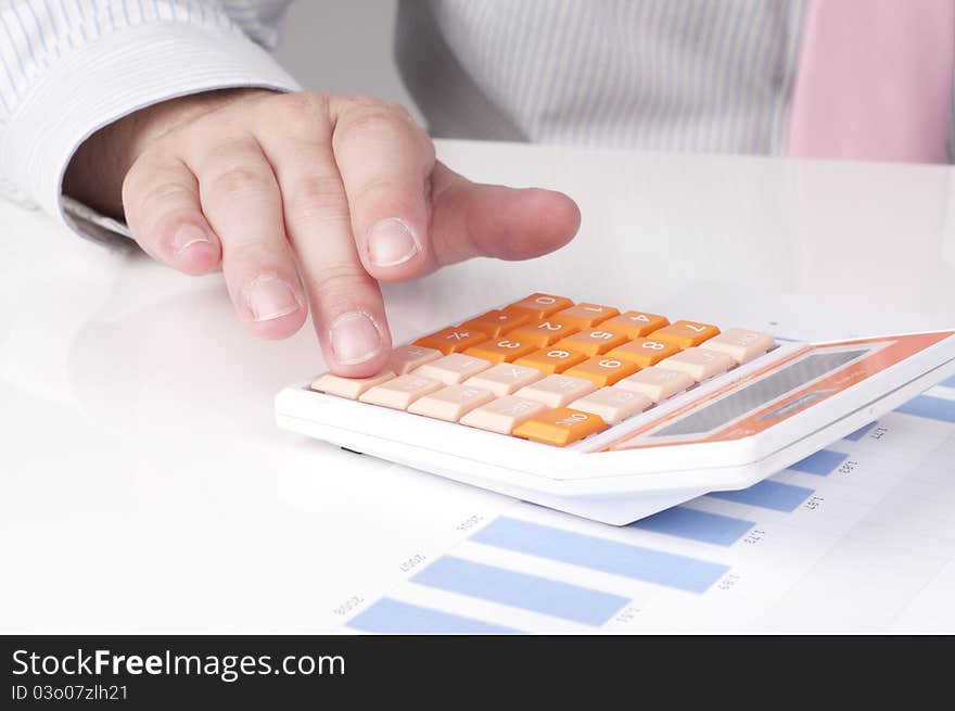 A businessman at work with a calculator. A businessman at work with a calculator