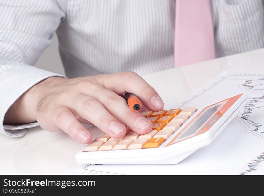 A businessman at work with a calculator. A businessman at work with a calculator