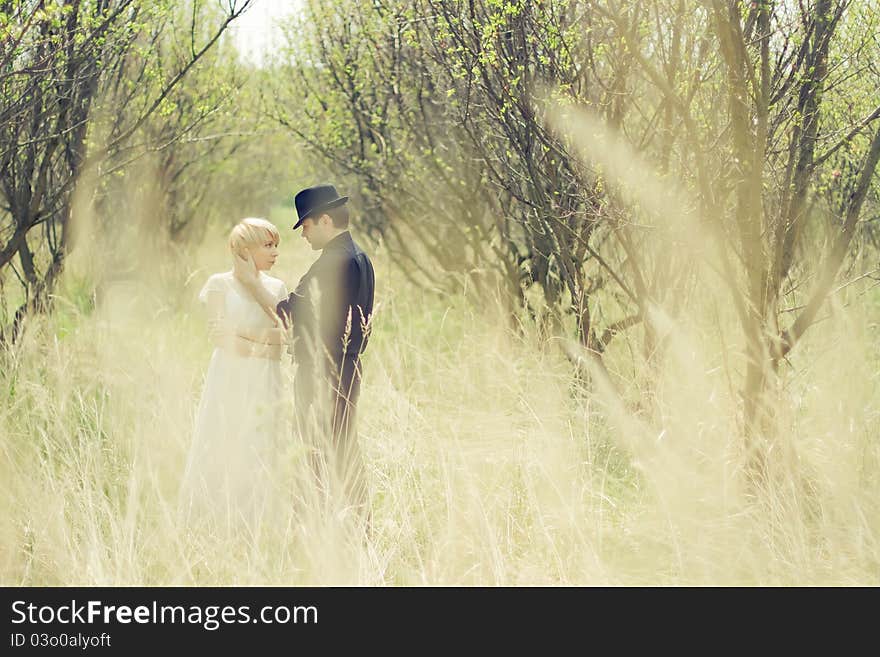 Young couple, newly wedded, dressed in retro style, in the garden