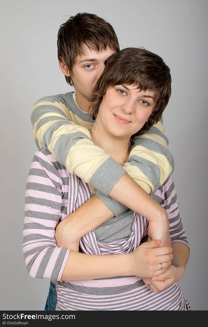 A happy couple in striped sweater hugs. A happy couple in striped sweater hugs