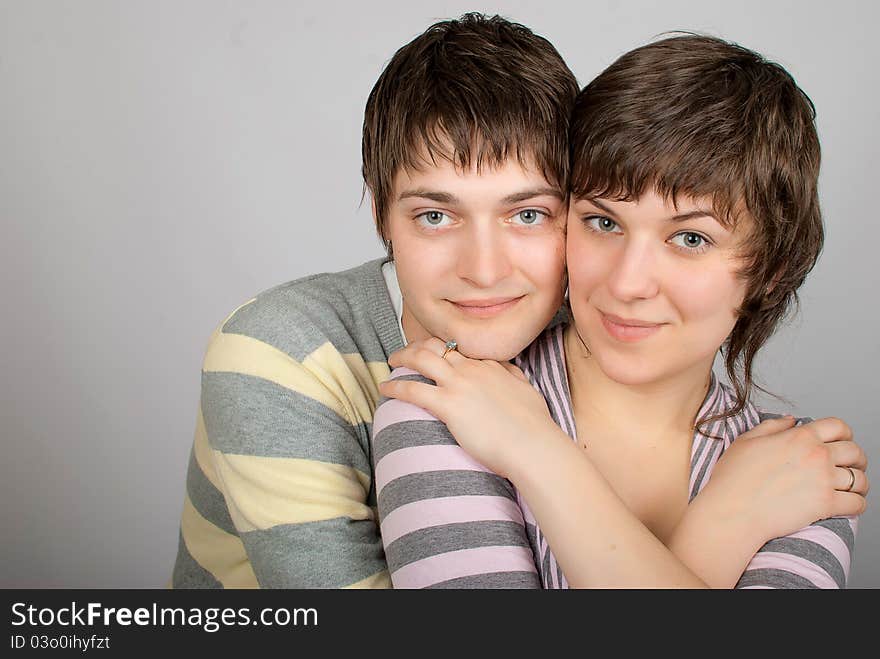 A happy couple in striped sweater hugs. A happy couple in striped sweater hugs