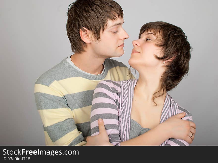 A happy couple in striped sweater hugs. A happy couple in striped sweater hugs