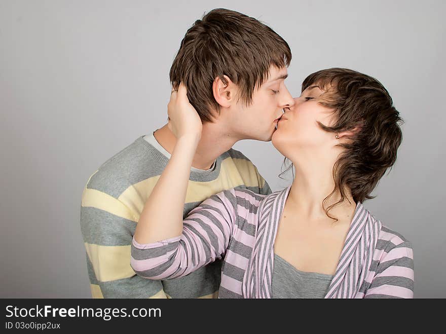 A happy couple in striped sweater hugs. A happy couple in striped sweater hugs