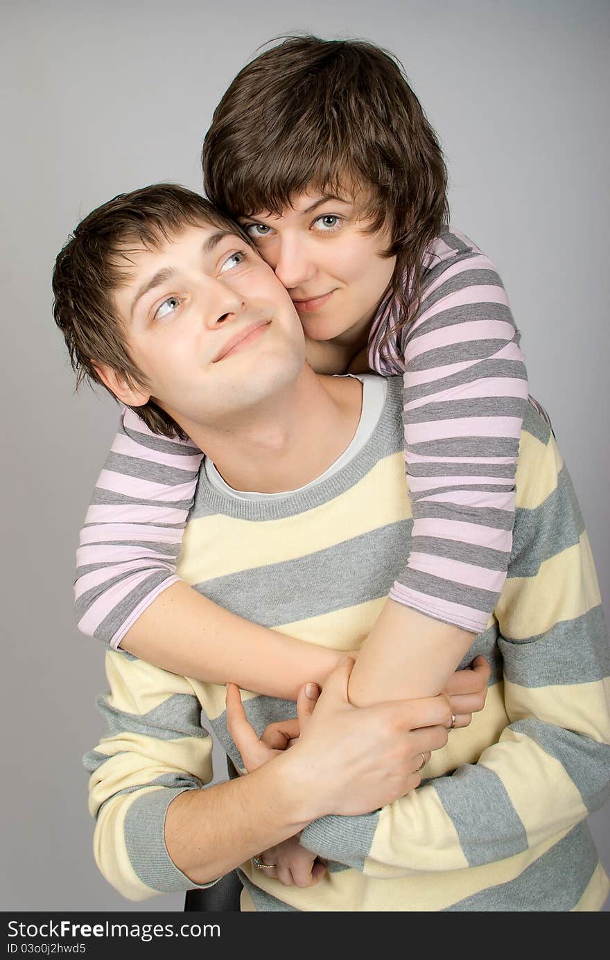 A happy couple in striped sweater hugs. A happy couple in striped sweater hugs