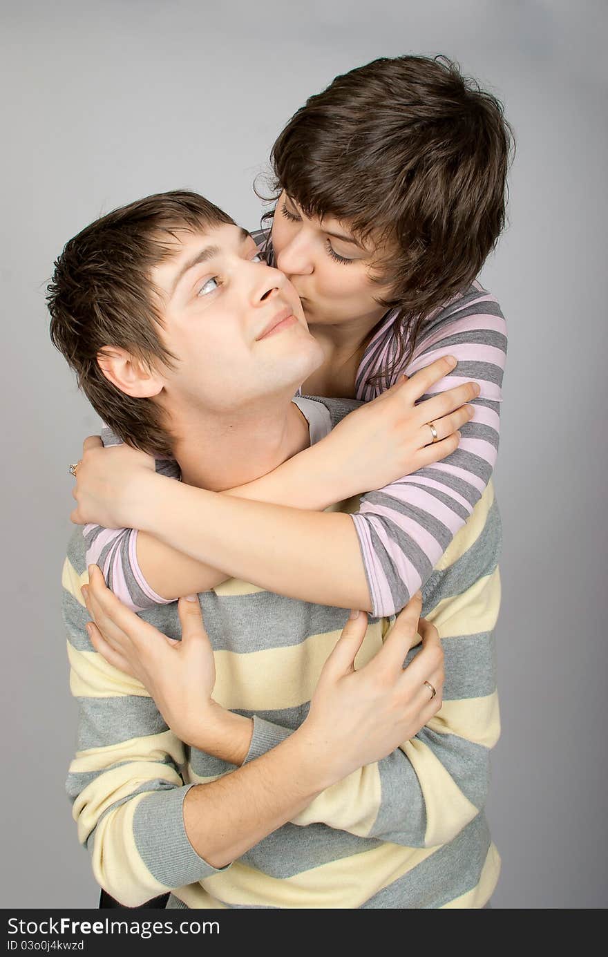 A happy couple in striped sweater hugs. A happy couple in striped sweater hugs