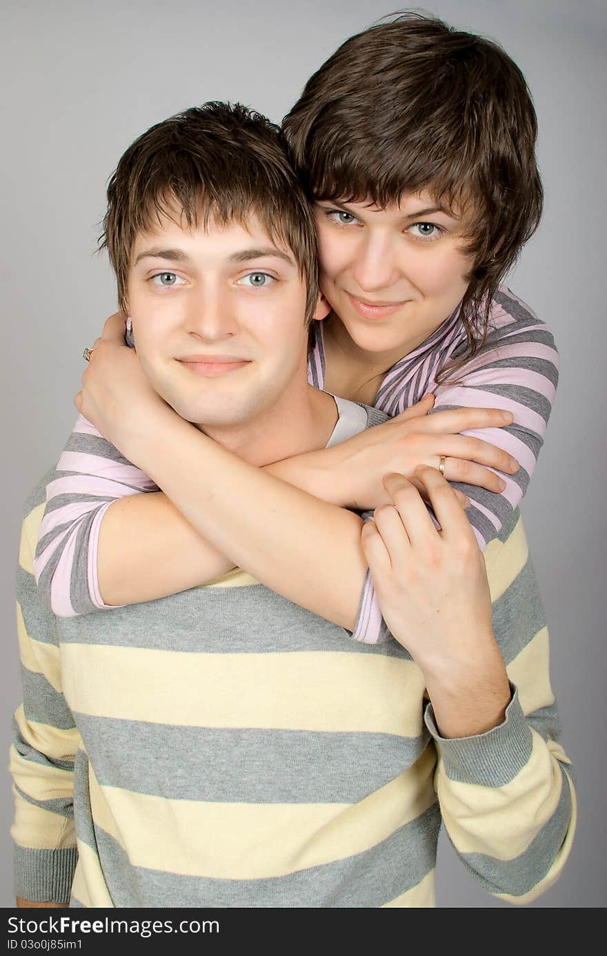 A happy couple in striped sweater hugs. A happy couple in striped sweater hugs