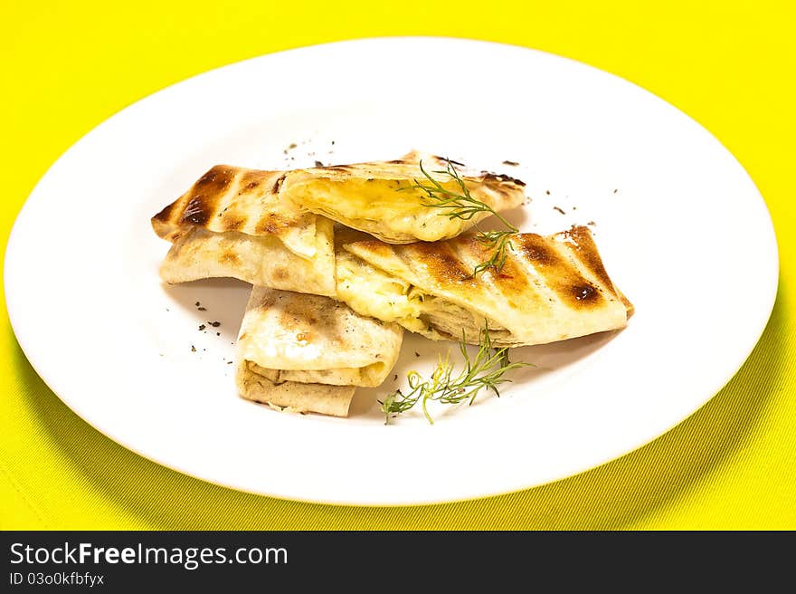 A grilled sandwich of melting cheese, on a white plate