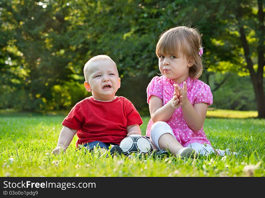 Brother and sister sitting on the grass