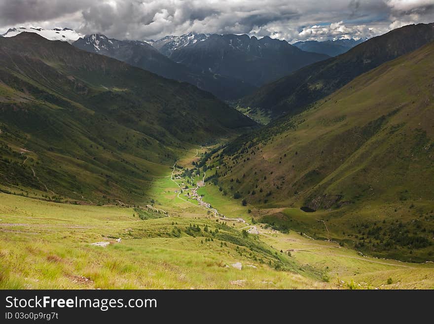 Green Valley with cloudy sky. Panorama by the top of Viso Valley. Brixia province, Lombardy region, Italy. Green Valley with cloudy sky. Panorama by the top of Viso Valley. Brixia province, Lombardy region, Italy