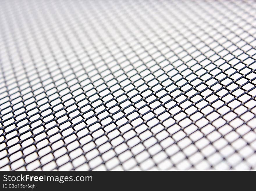 Metal grill of diamond shaped mesh, used in the construction industry, against black. Metal grill of diamond shaped mesh, used in the construction industry, against black.