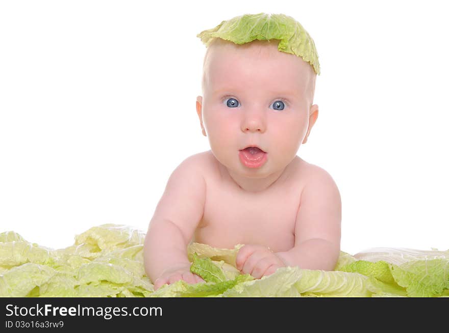 Small child sitting among the cabbage leaves