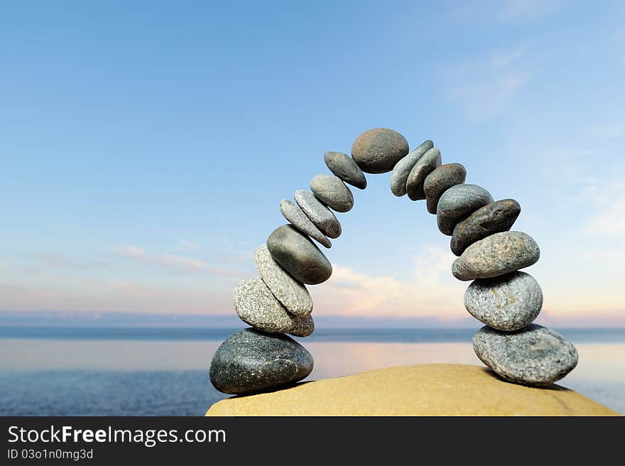 Grey pebbles are formed as curve on the seacoast. Grey pebbles are formed as curve on the seacoast