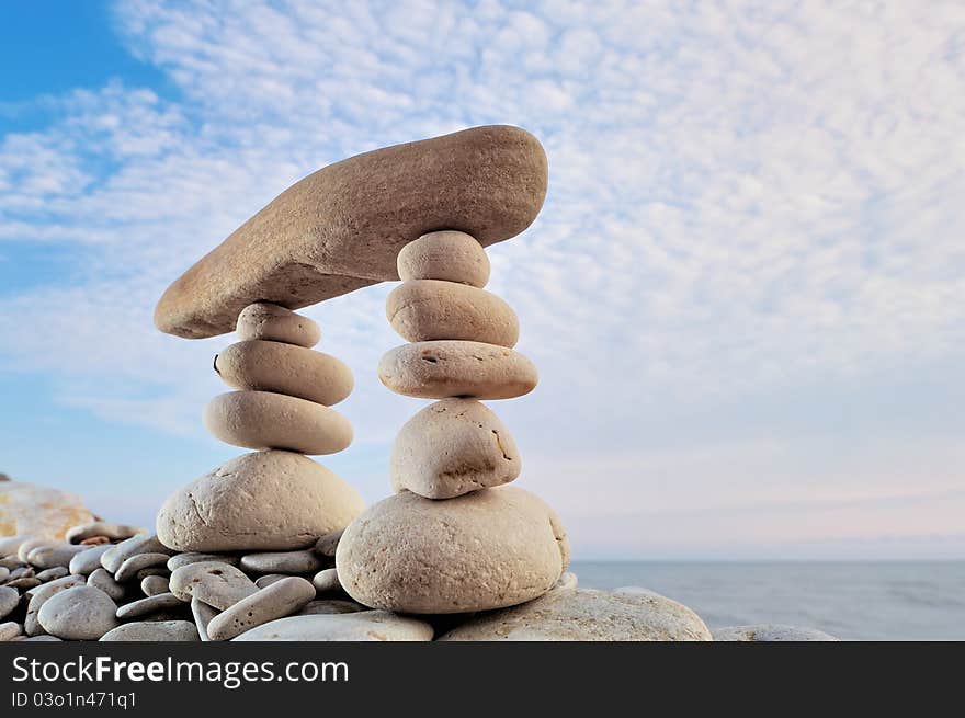 Long horizontal stone is between a stack of pebbles. Long horizontal stone is between a stack of pebbles