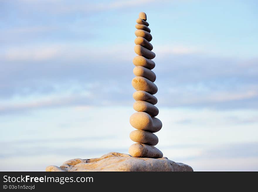 White pebbles composed one on another, against the sky