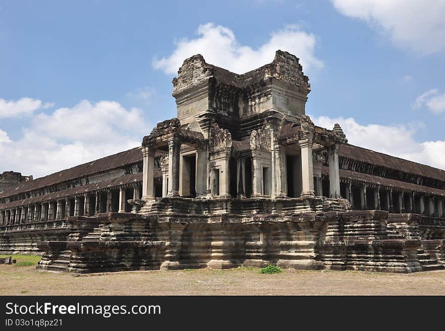 Khmer Building with symmetrical architectural elements and clouds forming a halo above the main towers and long corridors.