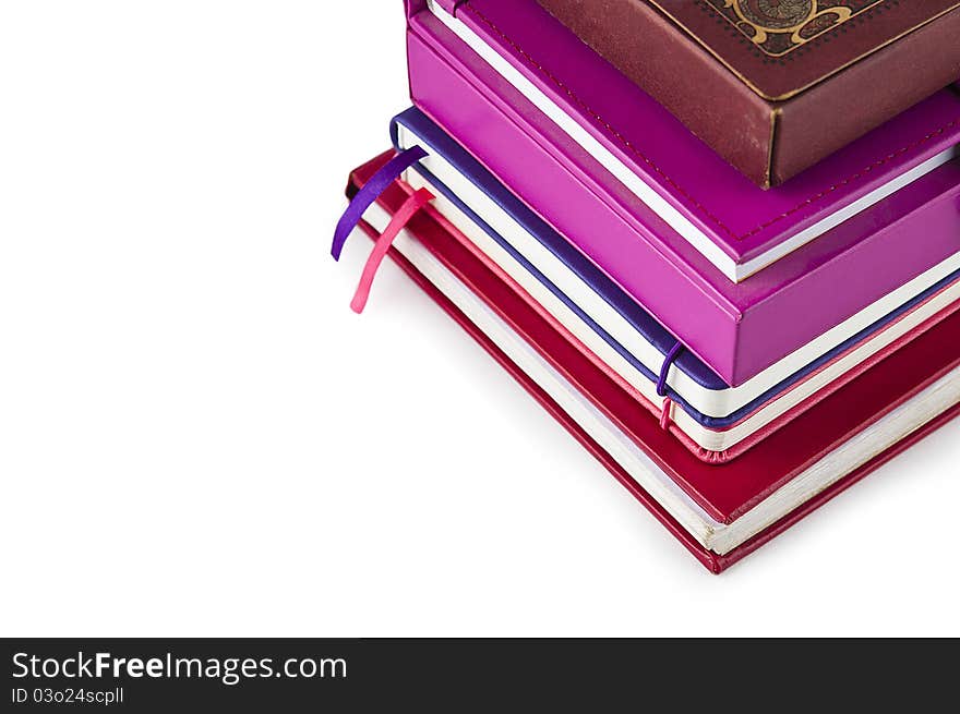 A stack of books and notebooks on a white background