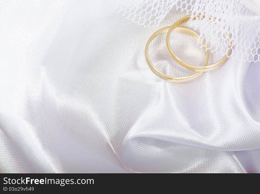 Two gold wedding rings on a white