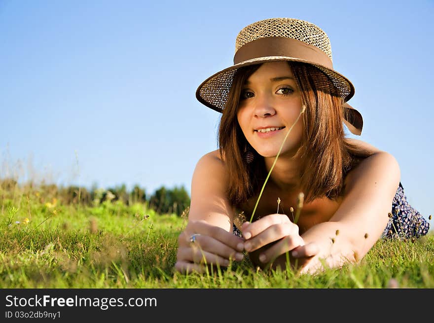 Young nice attentive woman lies on green grass