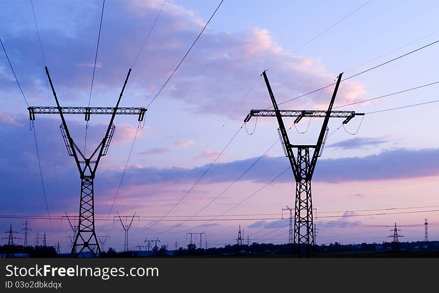 High voltage electricity pylon over evening sky