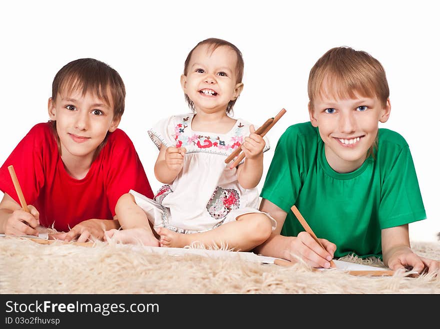 Portrait of a three children drawing on carpet