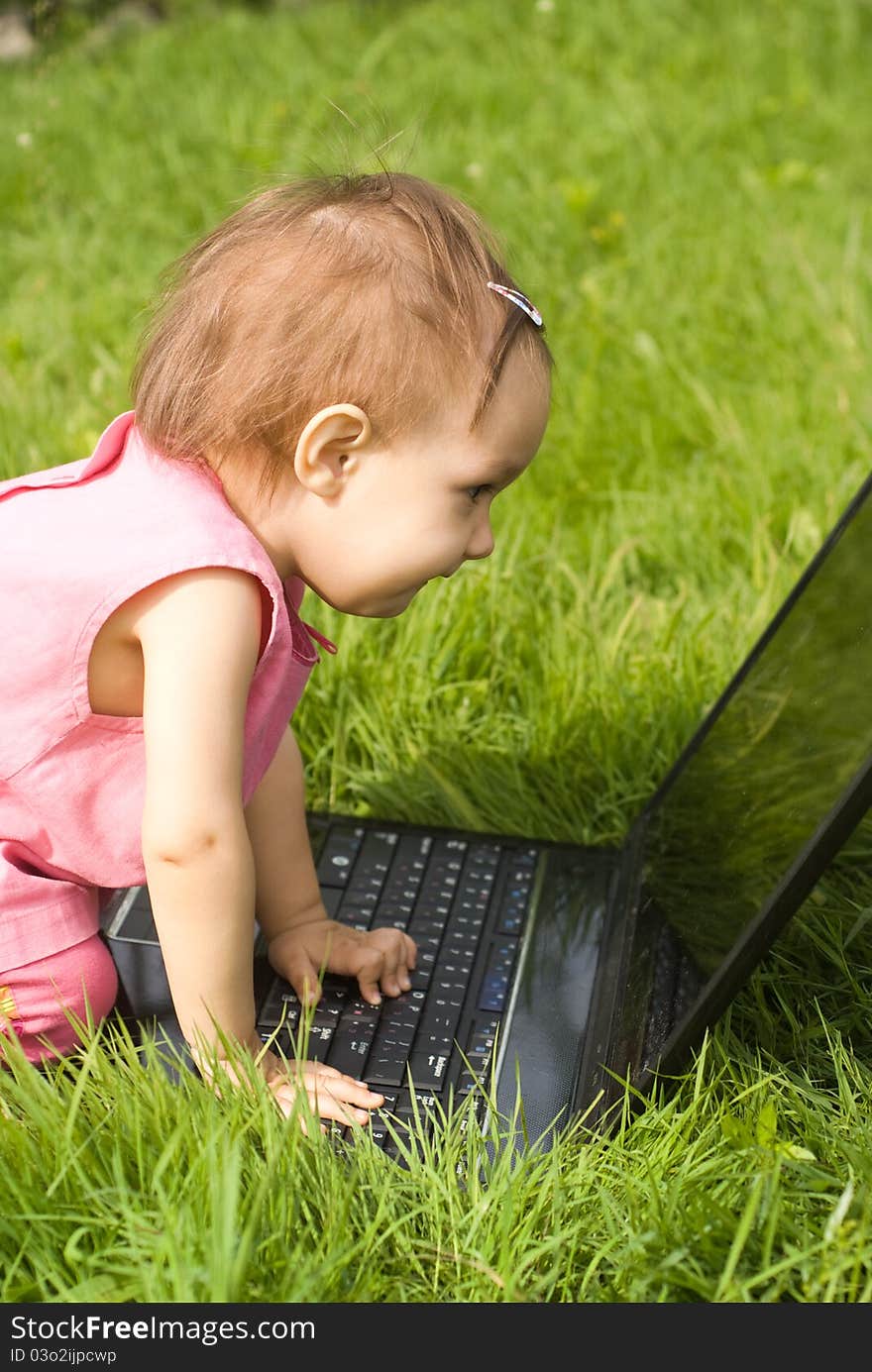 Little girl with a laptop at nature. Little girl with a laptop at nature