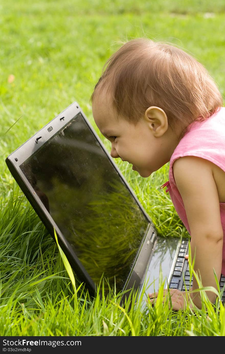 Little girl with a laptop at nature. Little girl with a laptop at nature