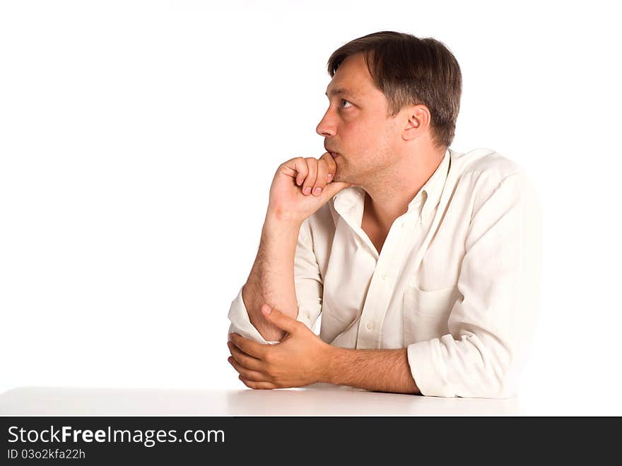 Cute adult man sitting at table on white. Cute adult man sitting at table on white