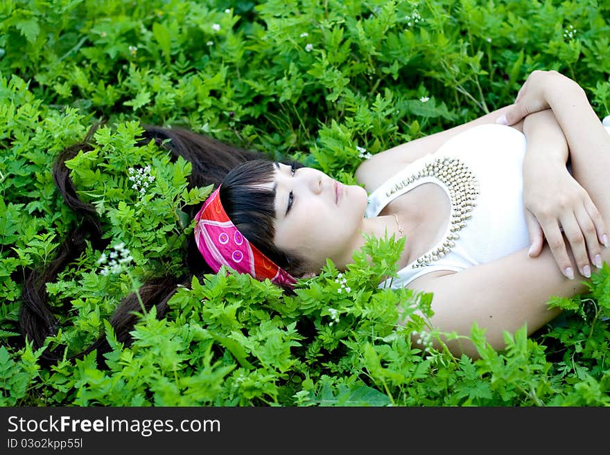 Closeup portrait of a beautiful girl lying on grass