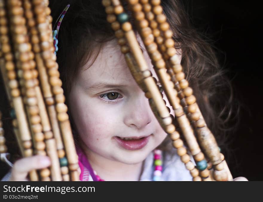 Surprised little girl behind the coral curtain