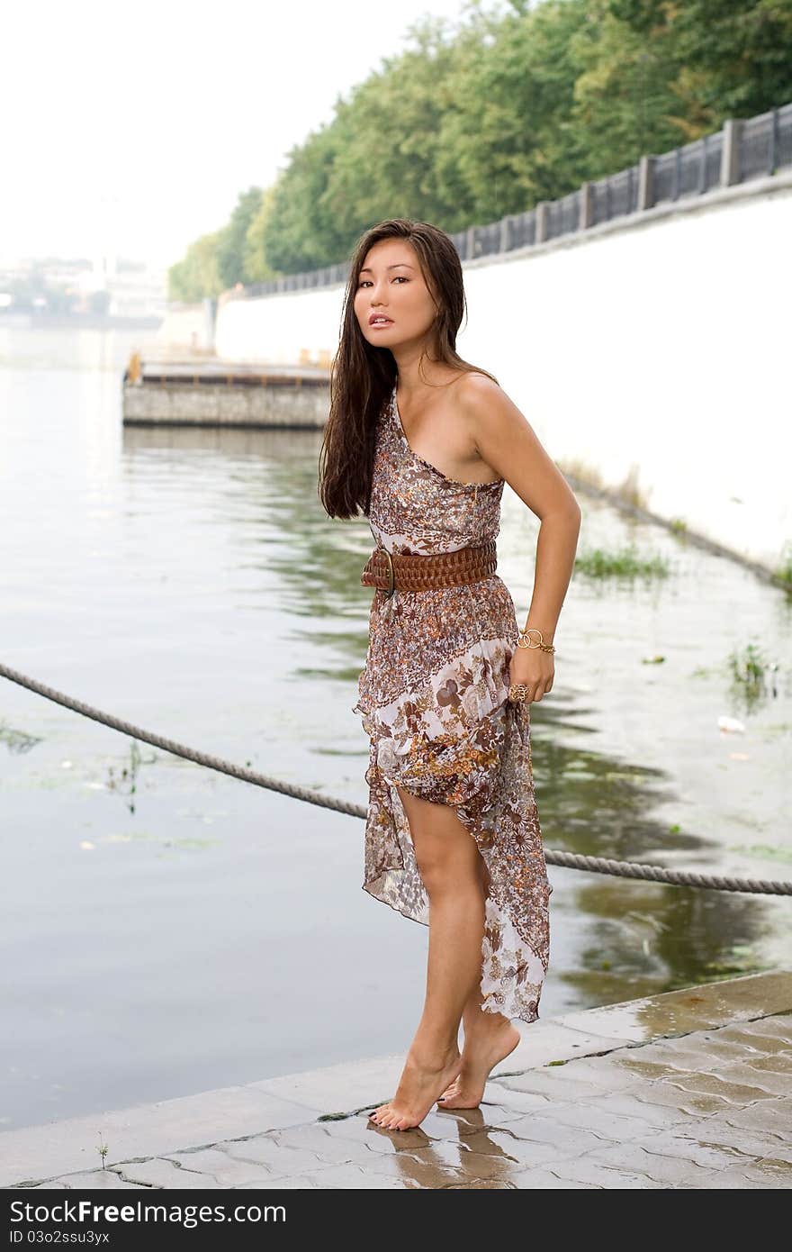 Beautiful girl walking near river in summer