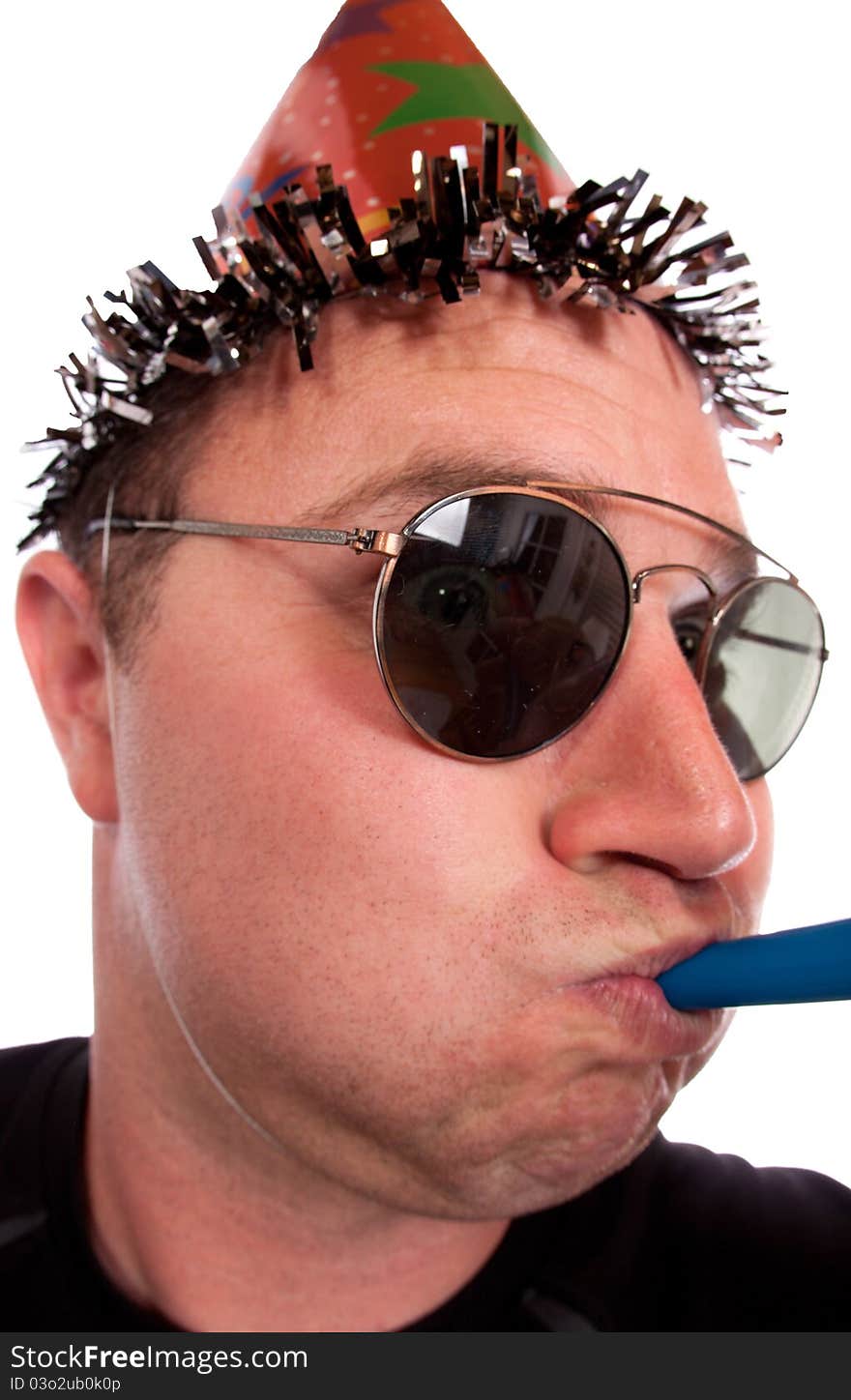 A goofy birthday boy blows his party horn. He is wearing a birthday hat. Image is isolated on white. A goofy birthday boy blows his party horn. He is wearing a birthday hat. Image is isolated on white.