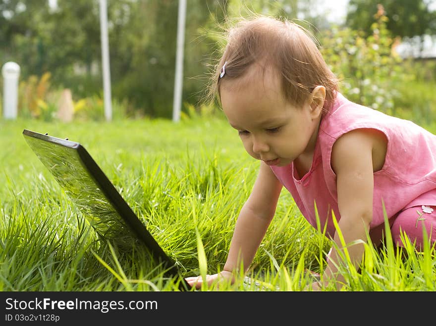 Little girl with a laptop at nature. Little girl with a laptop at nature