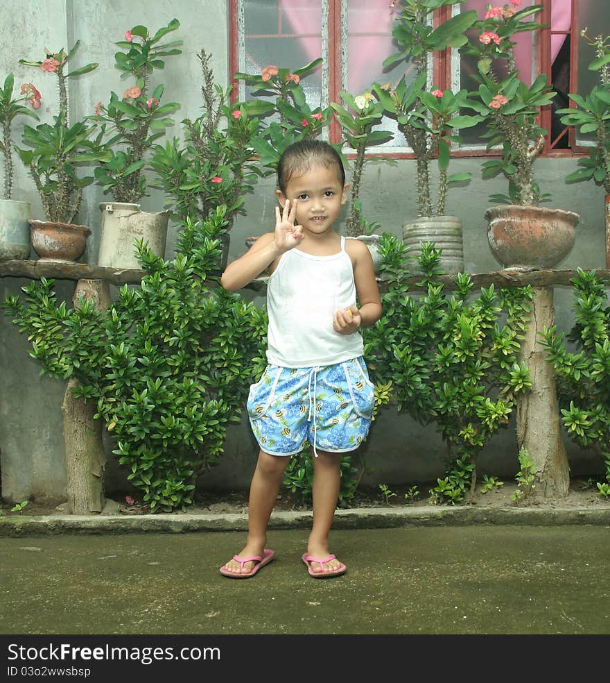 Philippines girl posing smiling and holding three fingers up and mandarin. Philippines girl posing smiling and holding three fingers up and mandarin