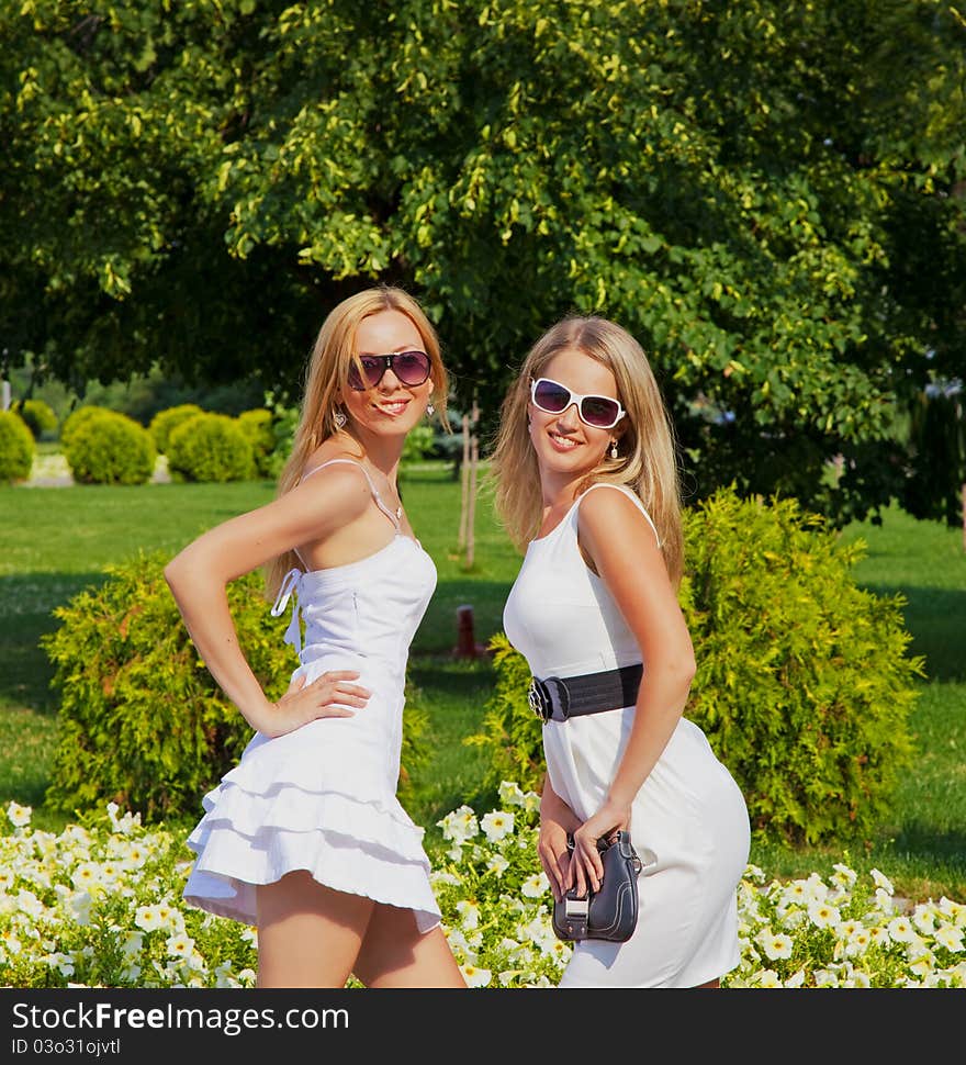 Two girls in white dresses in summer park. Two girls in white dresses in summer park