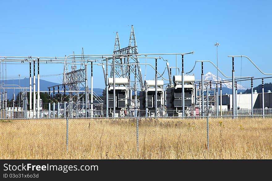 Tall towers distributing power-lines to various directions in an open field. Tall towers distributing power-lines to various directions in an open field.