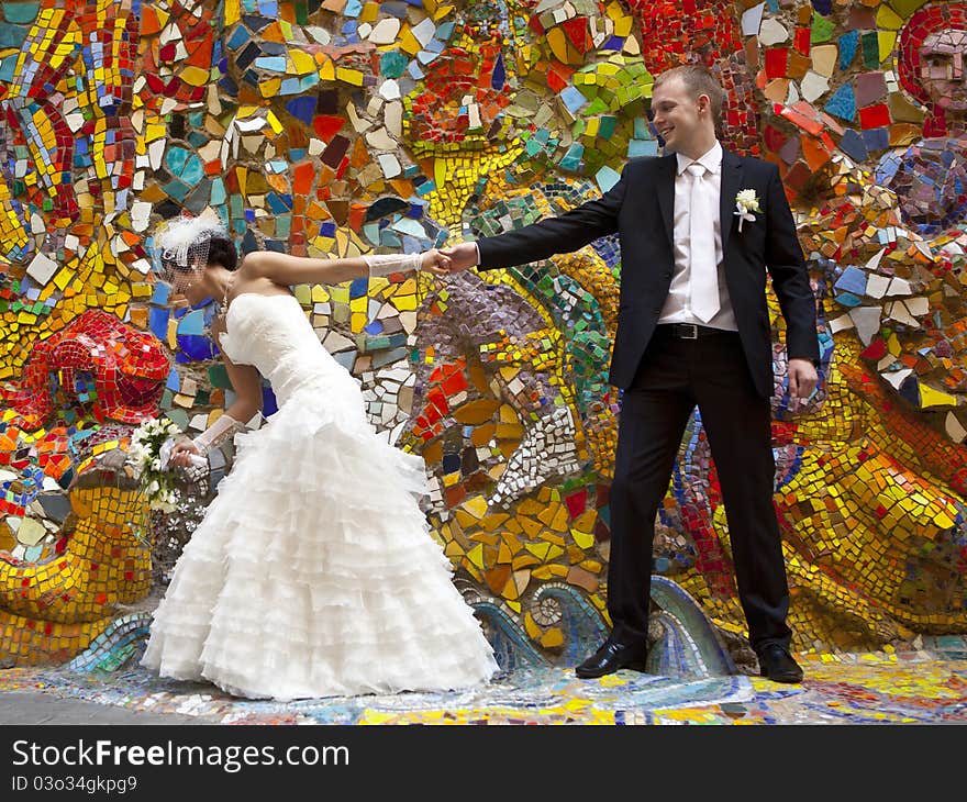 Bride and groom standing at the colorful walls. Bride and groom standing at the colorful walls