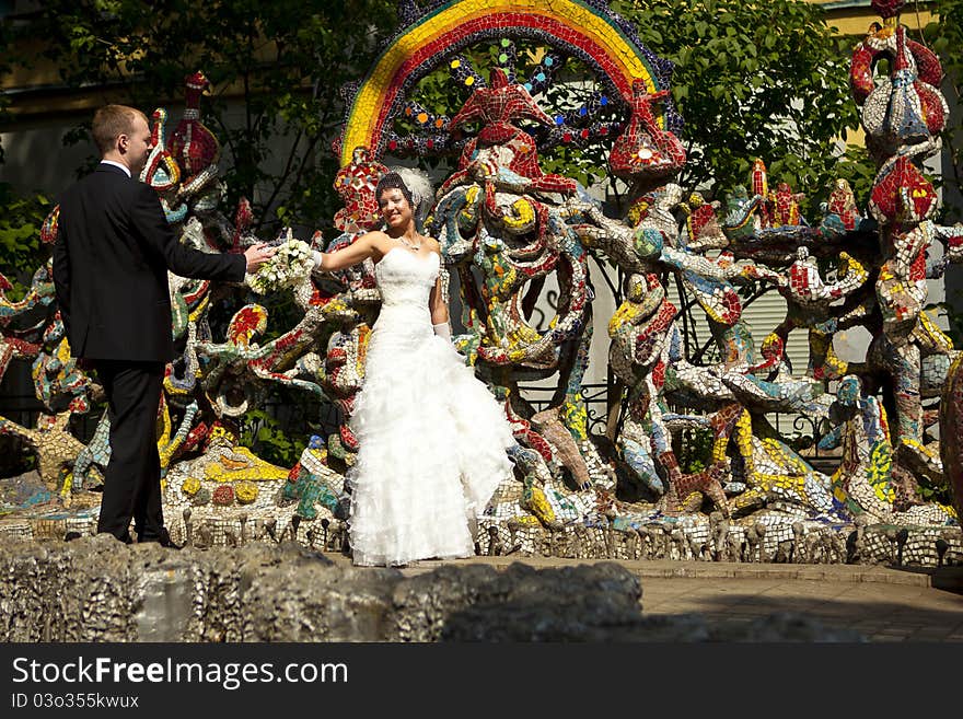 Bride and groom standing at the colorful walls. Bride and groom standing at the colorful walls