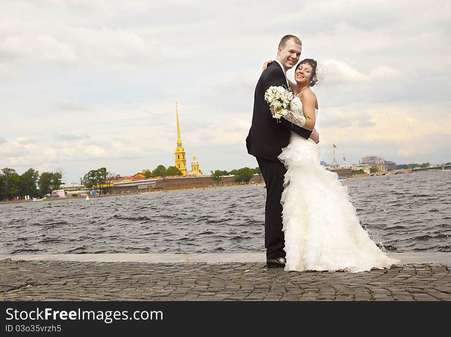 Bride and groom walking on the waterfront. Bride and groom walking on the waterfront