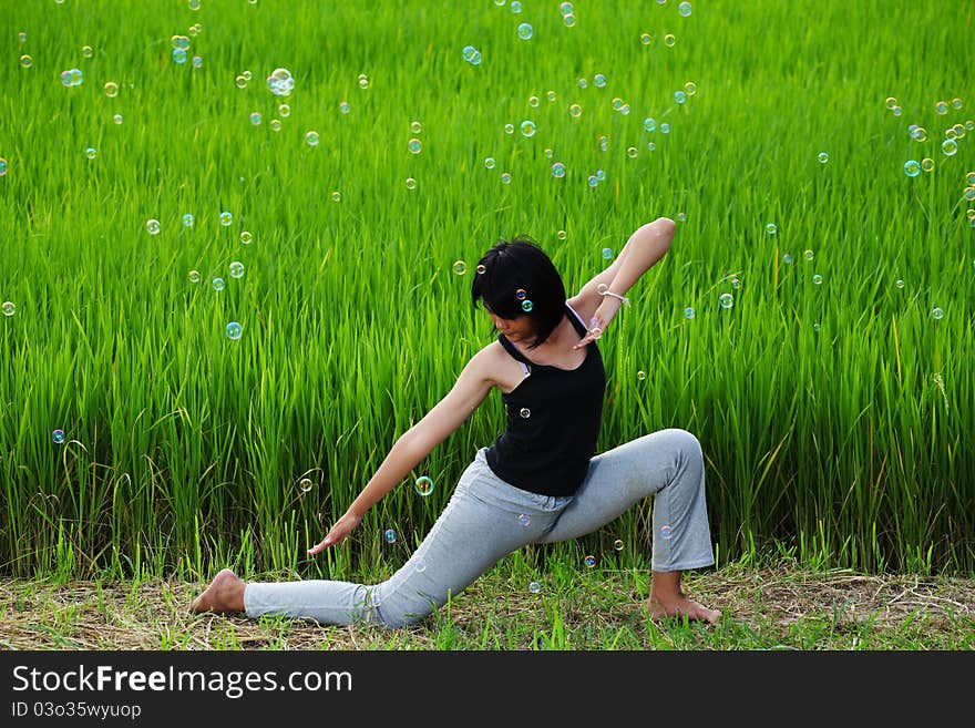 Girl practicing yoga with paddy field background. Girl practicing yoga with paddy field background