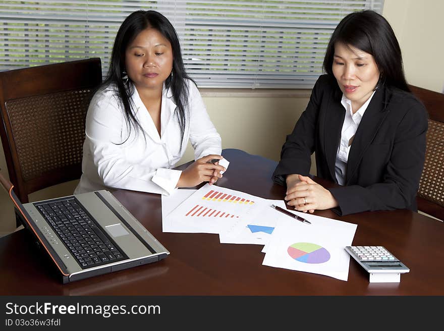 Two Asian Women at desk with laptop