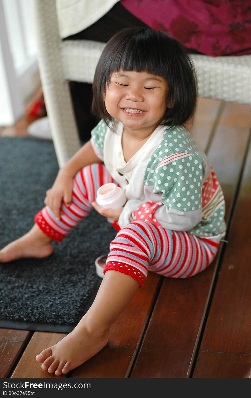 Little asian girl smiling and close her eyes